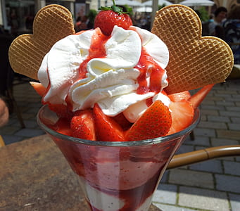 sliced strawberries with white icing on clear glass cup thumbnail