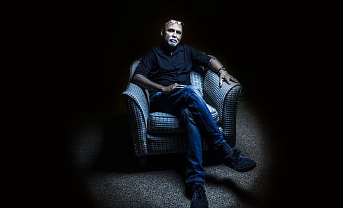 man sitting on sofa chair while crossing legs thumbnail