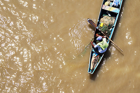 aerial photography of man on blue boat while holding boat paddle thumbnail