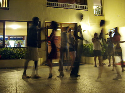 people walking and standing in front of brown concrete building during nighttime thumbnail