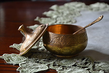 round gold bowl with spoon on table thumbnail