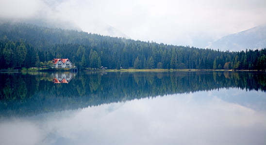 calm body of water near white concrete house thumbnail