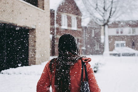 woman wearing red winter coat standing near the building thumbnail