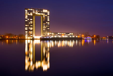 lighted building near body of water at nighttime thumbnail