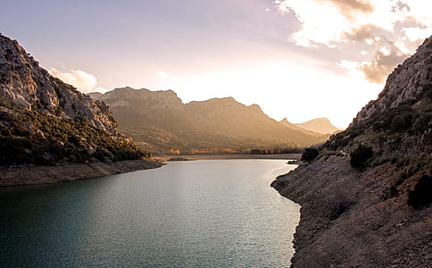 body of water near mountain at daytime thumbnail