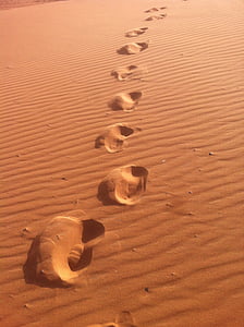 footprints on sand during daytime thumbnail