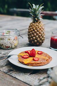 strawberry pancake on plate beside pineapple fruit thumbnail
