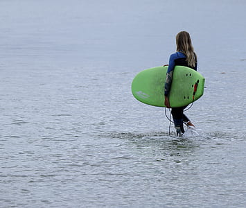 person holding green surfboard during daytiime thumbnail