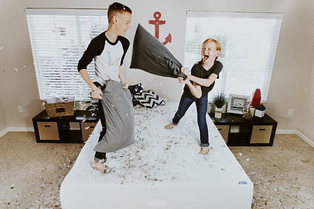 boy and girl holding gray pillows thumbnail