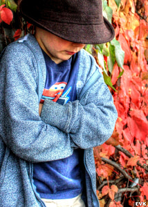 shallow focus photography of boy in black hat and blue cardigan thumbnail