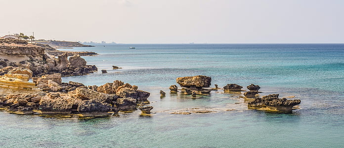 rock monoliths on body of water thumbnail