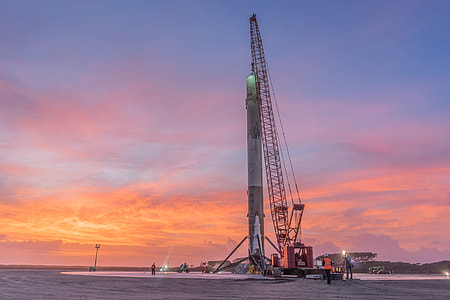 photo of crane on gray sand during sunset thumbnail