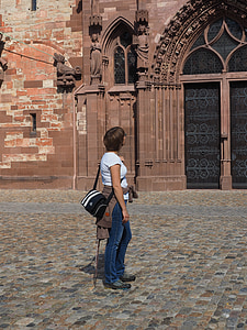 woman standing beside brown painted concrete building thumbnail