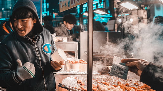 man standing at the front of food stall thumbnail