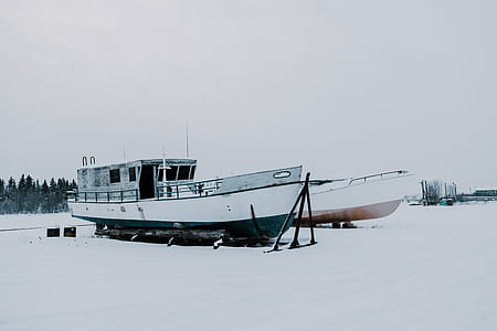 photography of two boats on snow coated ground thumbnail