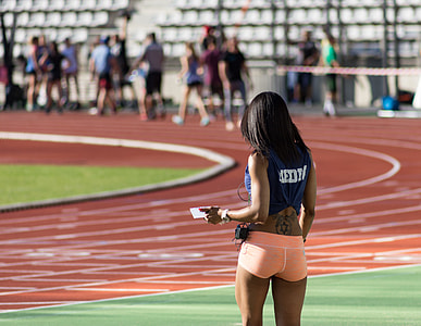 woman standing near oval track thumbnail