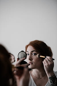 woman holding makeup brush thumbnail