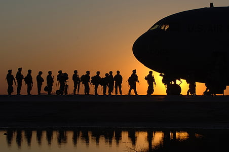silhouette of people falling in line in front of plane thumbnail
