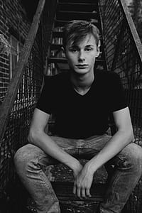 man sitting on black steel stair thumbnail