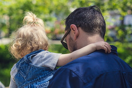 man carrying toddler during dayt ime thumbnail