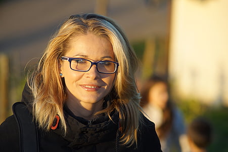 selective focus photography of woman wearing black framed eyeglasses and black coat thumbnail