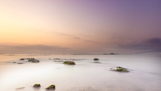 calm water and rock formations during golder hour thumbnail