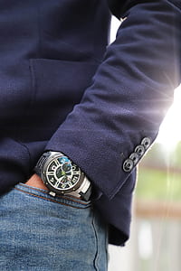 person wears round black chronograph watch thumbnail