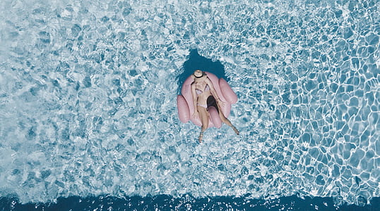 person laying on floater above body of water thumbnail