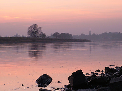 silhouette photography of body of water during orange sky thumbnail