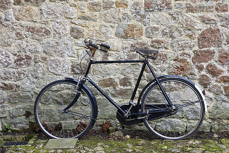 black hybrid bicycle beside brick wall thumbnail
