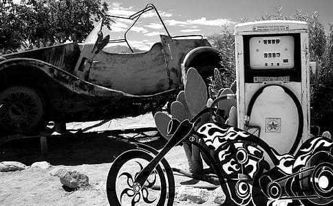 grayscale photo cruiser motorcycle beside classic car thumbnail