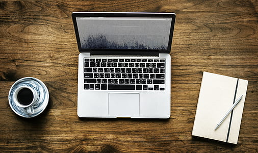 MacBook Pro beside white-and-black ceramic teacup and saucer and white tablet folio case thumbnail
