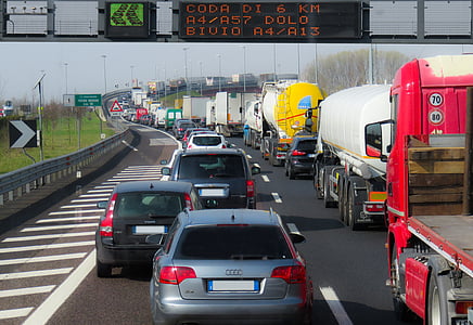 row of cars on highway lane under digital signboard at daytime thumbnail