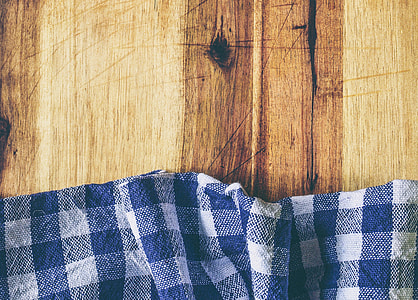 blue and white gingham textile on brown wooden surface thumbnail