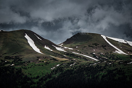 green, white, and brown mountain under cloudy sky thumbnail