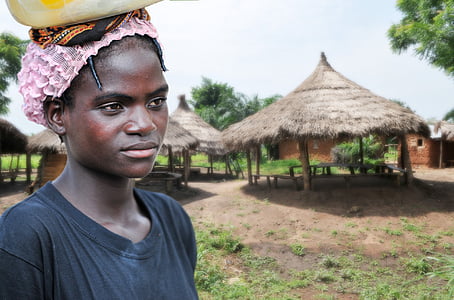 women's black crew-neck shirt near a brown hut at daytime thumbnail