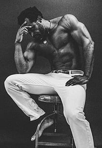 grayscale photography of man thinking pose while sitting on stool thumbnail