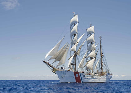 white and red galleon ship under blue sky thumbnail