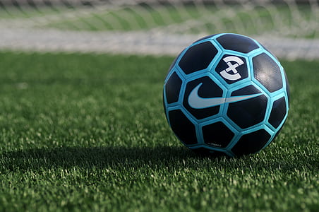 blue and black Nike soccer ball on green grass thumbnail