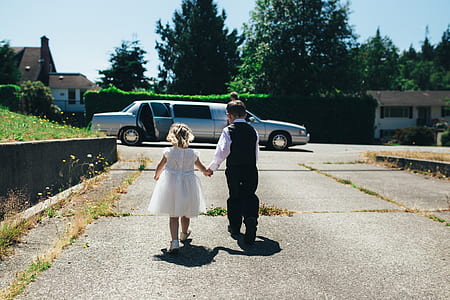 boy holding girl's hand walking towards limousine thumbnail