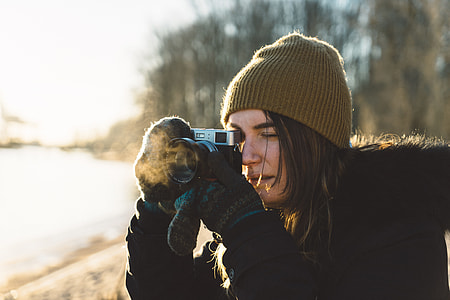 woman taking pic using MILC near tall trees thumbnail