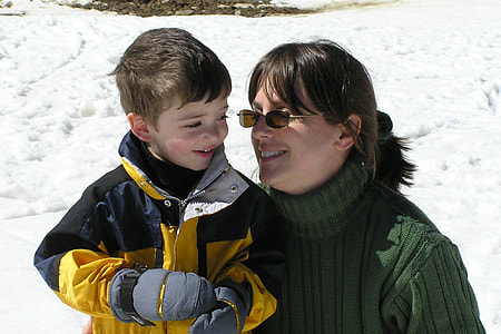 woman sitting beside boy wearing gray gloves thumbnail
