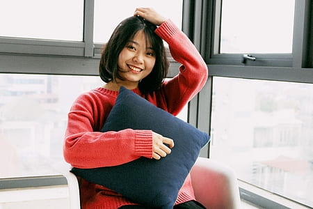 woman sitting on chair near window thumbnail