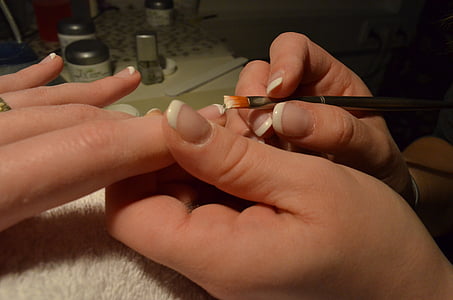 person holding nail polish brush thumbnail