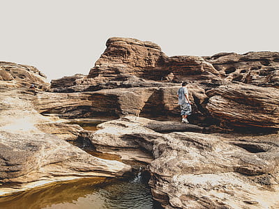 Person Standing on Brown Rocks thumbnail