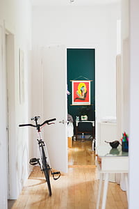 black and white mountain bicycle parked near door thumbnail