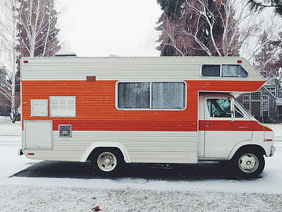 red and white RV trailer on snow covered land thumbnail
