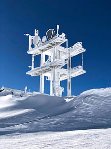 snow-covered field and tower during daytime thumbnail