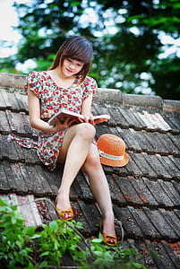 woman wears pink and multicolored floral cap-sleeved dress on the top of the roof thumbnail