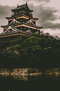 low-light photo of temple with green tree in front thumbnail